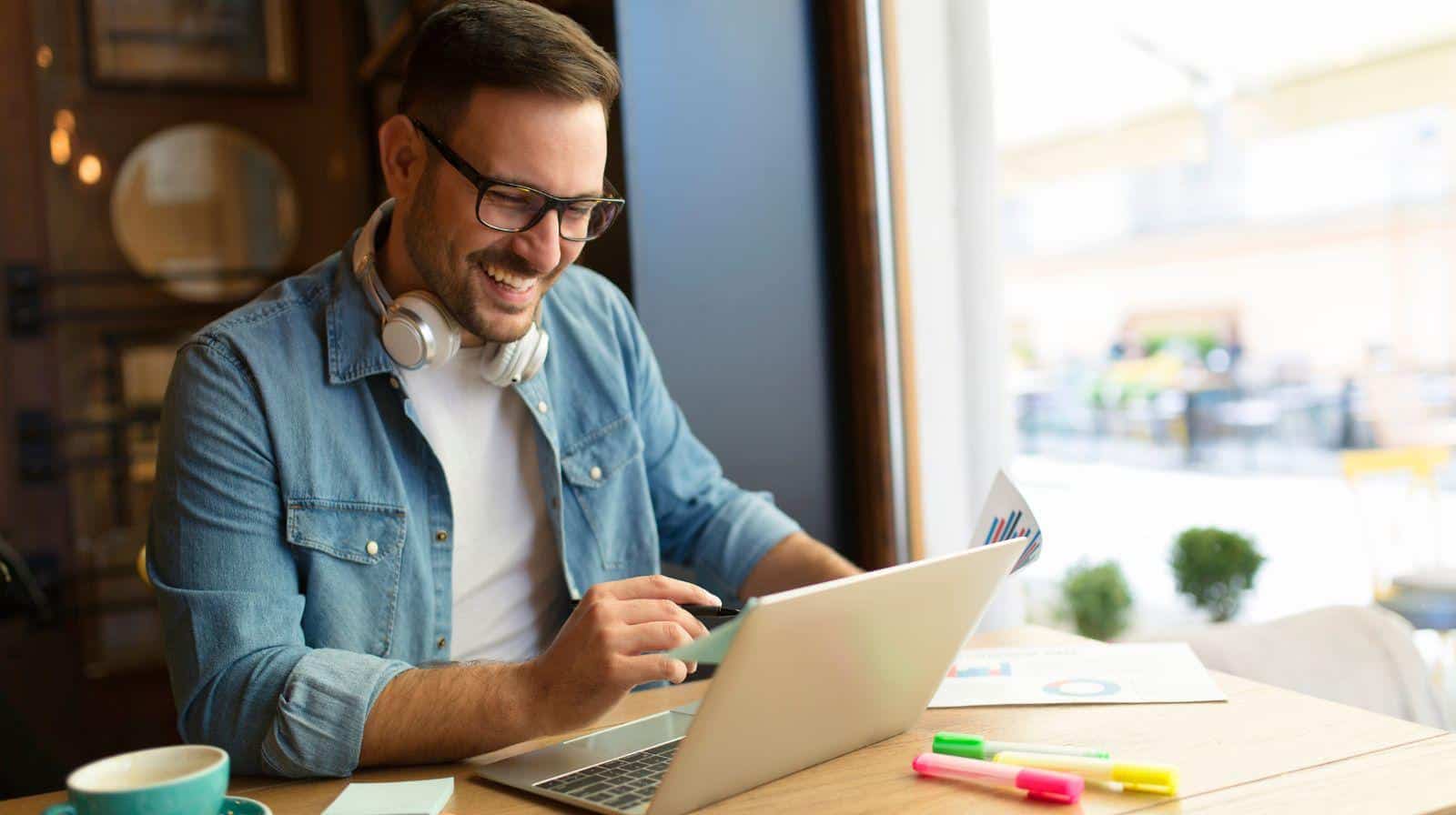 מהו עצמאי שאינו עונה להגדרה צעיר מסתכל על הלפטופ ומחייך